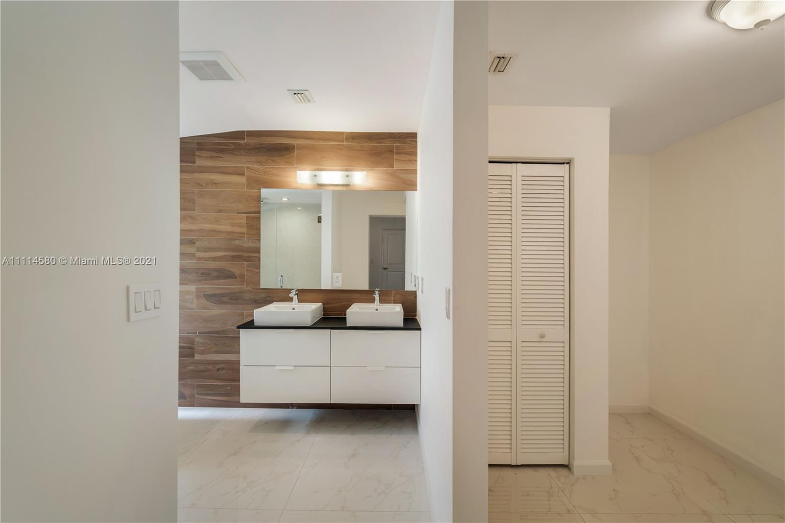 825 Southwest 28th Road Miami, FL 33129 - Photo 30 of 40 a bathroom with a double vanity sink and mirror