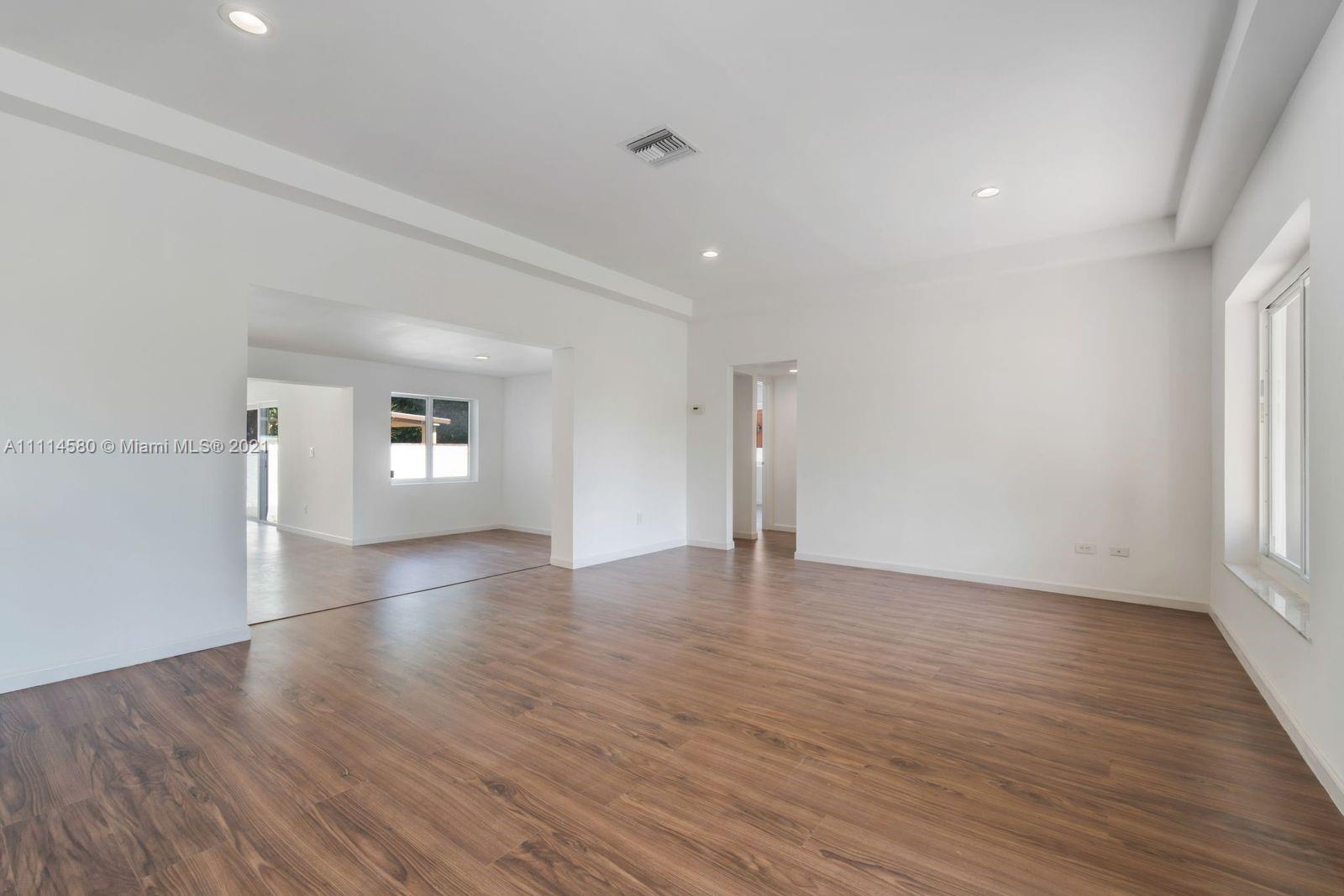 825 Southwest 28th Road Miami, FL 33129 - Photo 8 of 40 a view of an empty room with wooden floor and a window