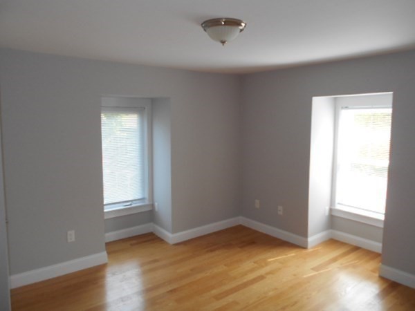 81 Alder Street Waltham, MA 02453 - Photo 11 of 38 an empty room with wooden floor and windows