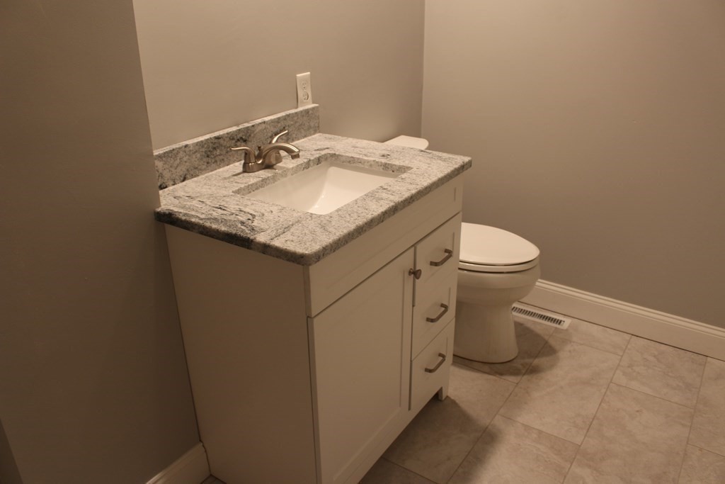81 Alder Street Waltham, MA 02453 - Photo 12 of 38 a bathroom with a granite countertop toilet and sink