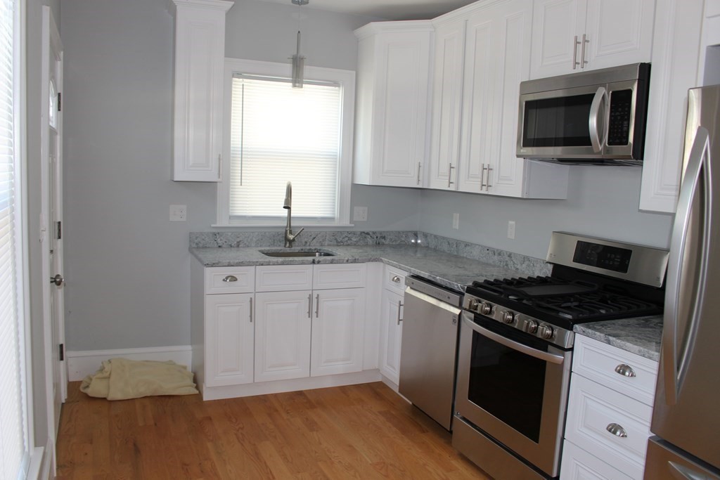 81 Alder Street Waltham, MA 02453 - Photo 2 of 38 a kitchen with granite countertop cabinets stainless steel appliances and wooden floor