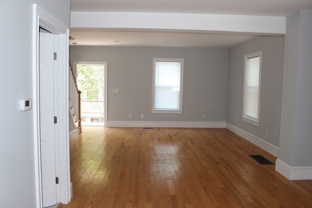 81 Alder Street Waltham, MA 02453 - Photo 5 of 38 a view of an empty room with wooden floor and a window