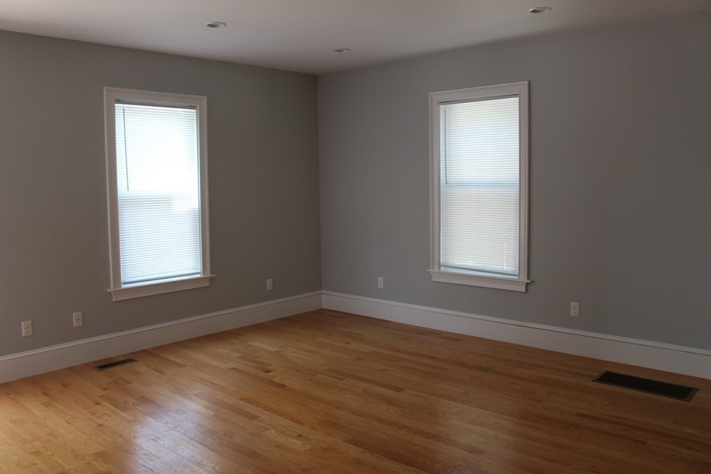 81 Alder Street Waltham, MA 02453 - Photo 6 of 38 a view of an empty room with wooden floor and a window