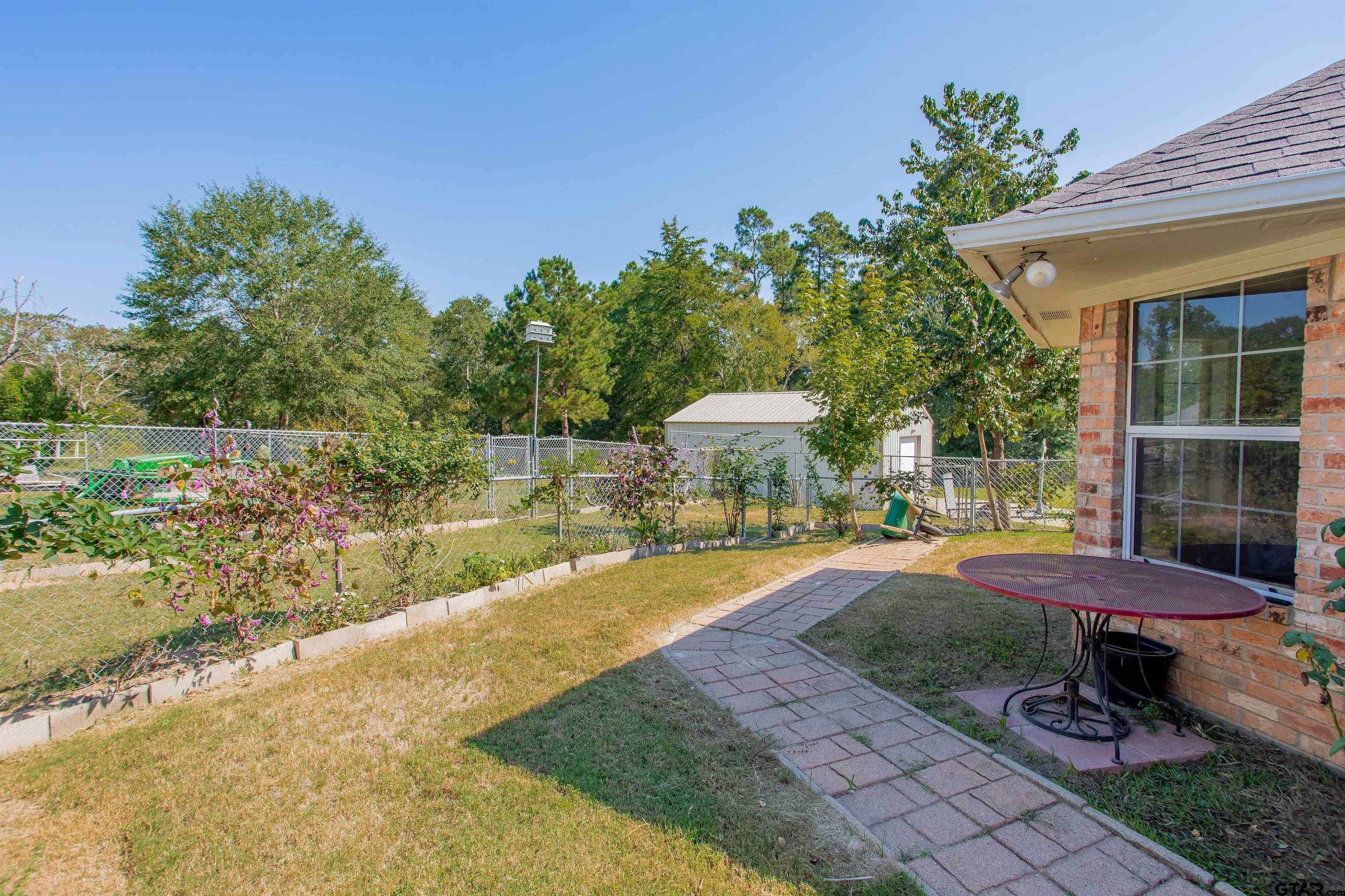 149 Pecan Street Frankston, TX 75763 - Photo 22 of 35 a view of a backyard with table and chairs under an umbrella