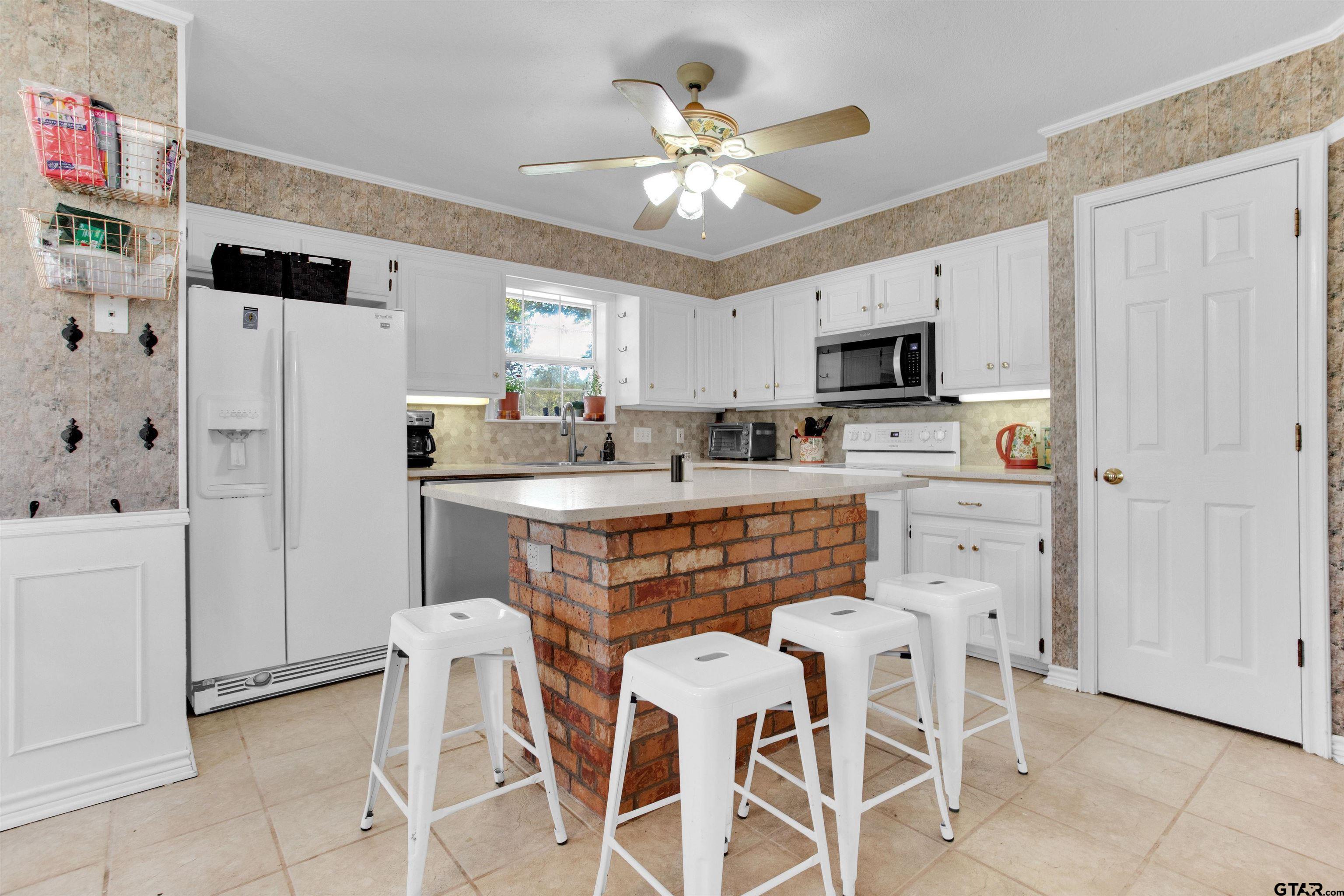 149 Pecan Street Frankston, TX 75763 - Photo 7 of 35 a kitchen with stainless steel appliances a stove a refrigerator and a refrigerator with white cabinets