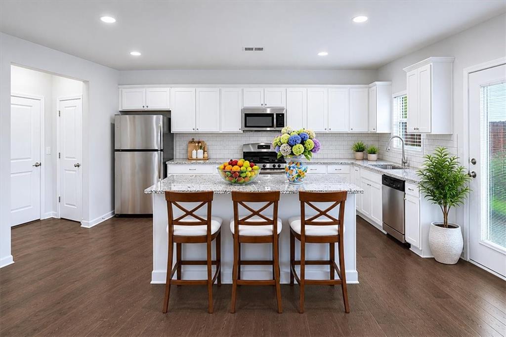 585 Summit Point Canton, GA 30114 - Photo 9 of 30 a kitchen with a table chairs refrigerator and microwave