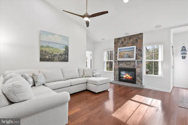 a living room with furniture a fireplace and a kitchen view