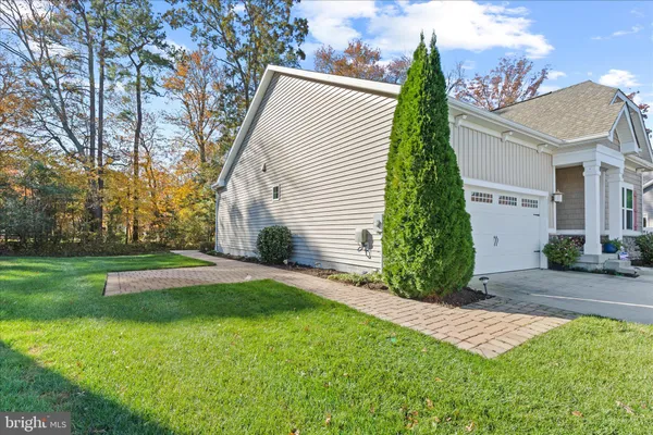 a front view of a house with a yard and lake view