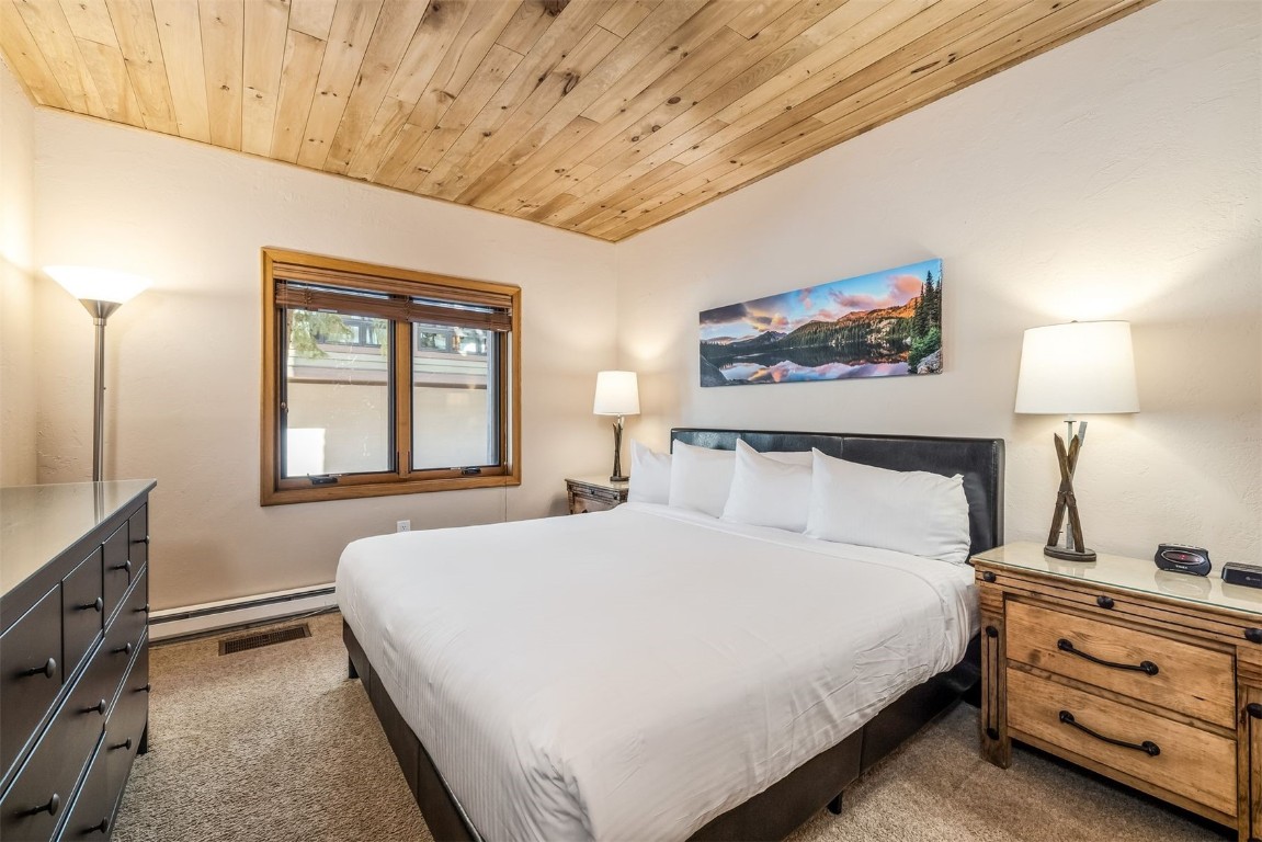 1203 West Keystone Road, Unit 2709 Keystone, CO 80435 - Photo 29 of 48 Bedroom with dark carpet, wooden ceiling, and a baseboard heating unit