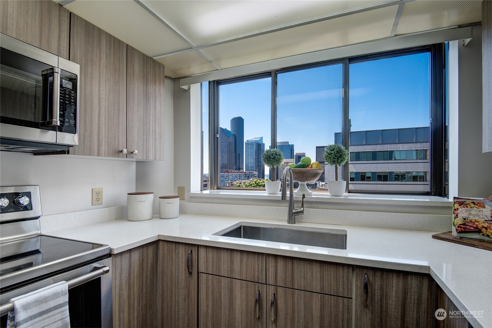 1120 Spring Street, Unit 1004 Seattle, WA 98104 - Photo 7 of 23 a kitchen with a sink and a microwave