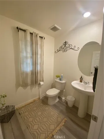 a bathroom with a toilet a sink and mirror