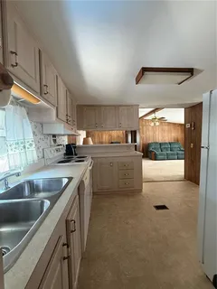 a kitchen with stainless steel appliances granite countertop a sink a stove and a refrigerator