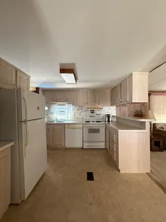 a kitchen with white cabinets and white appliances