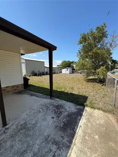 a backyard of a house with two trees and wooden fence