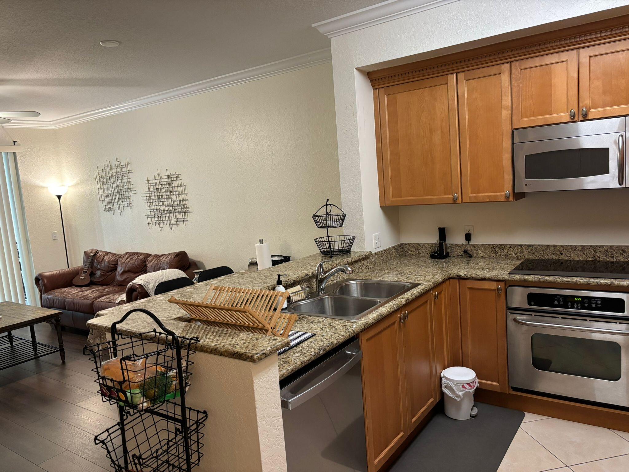 4112 Renaissance Way, Unit 112 Boynton Beach, FL 33426 - Photo 2 of 10 a kitchen with a sink stove and cabinets