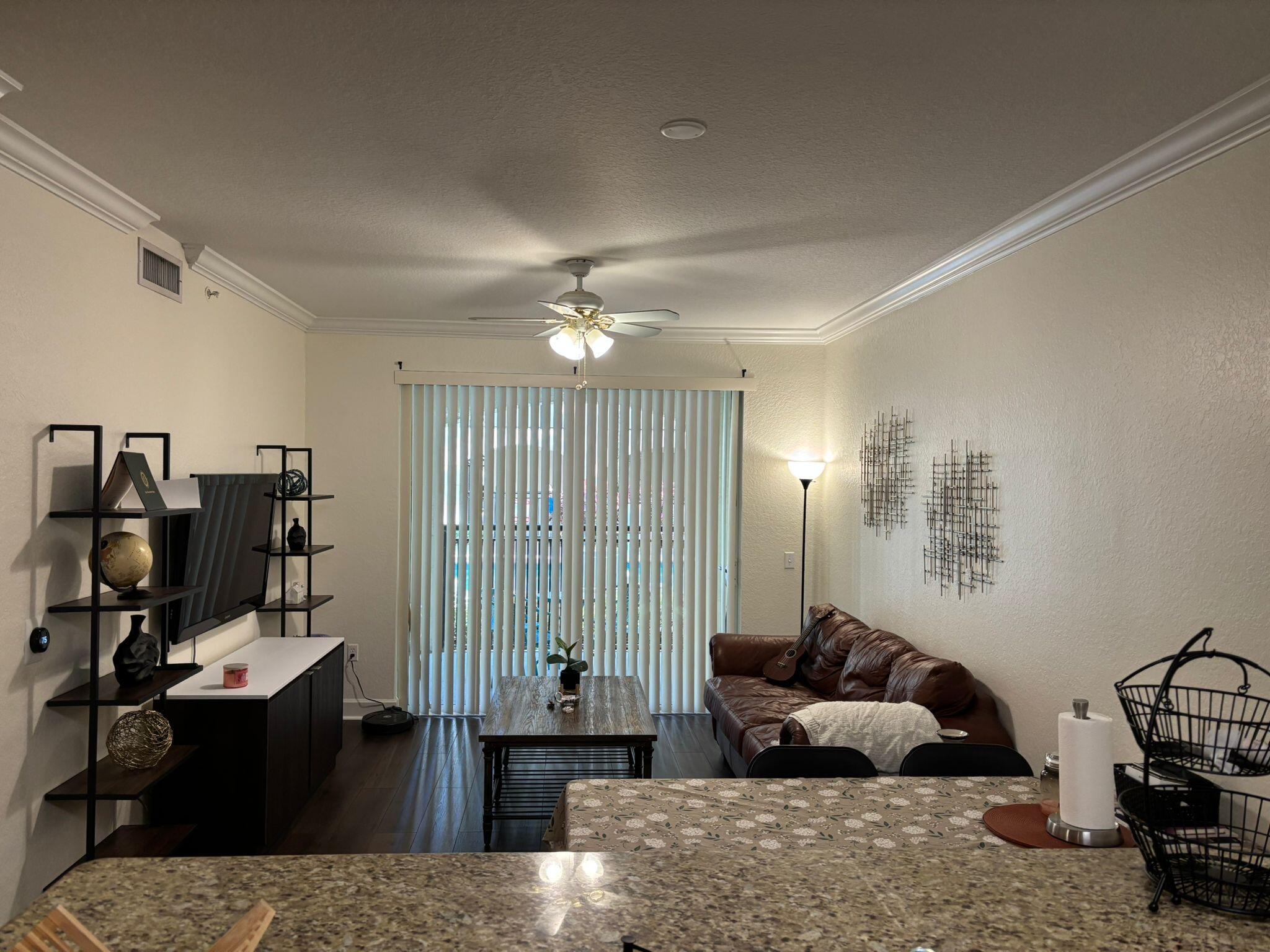 4112 Renaissance Way, Unit 112 Boynton Beach, FL 33426 - Photo 6 of 10 a living room with furniture and a chandelier