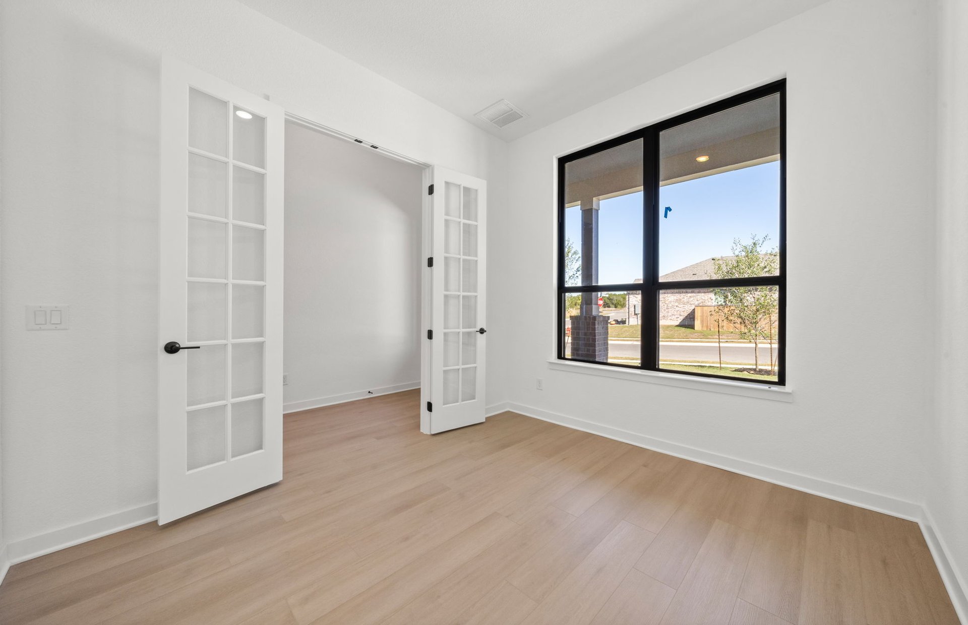 329 Muddy Creek Way Kyle, TX 78640 - Photo 14 of 22 an empty room with a window and wooden floor