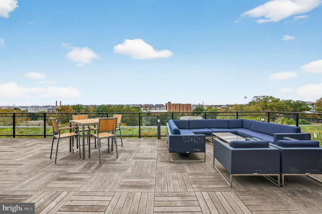 a view of roof deck with dining table and chairs