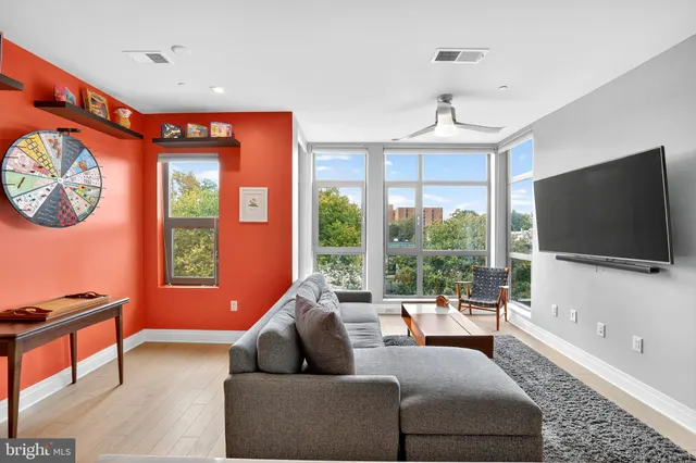 a living room with furniture a flat screen tv and a large window
