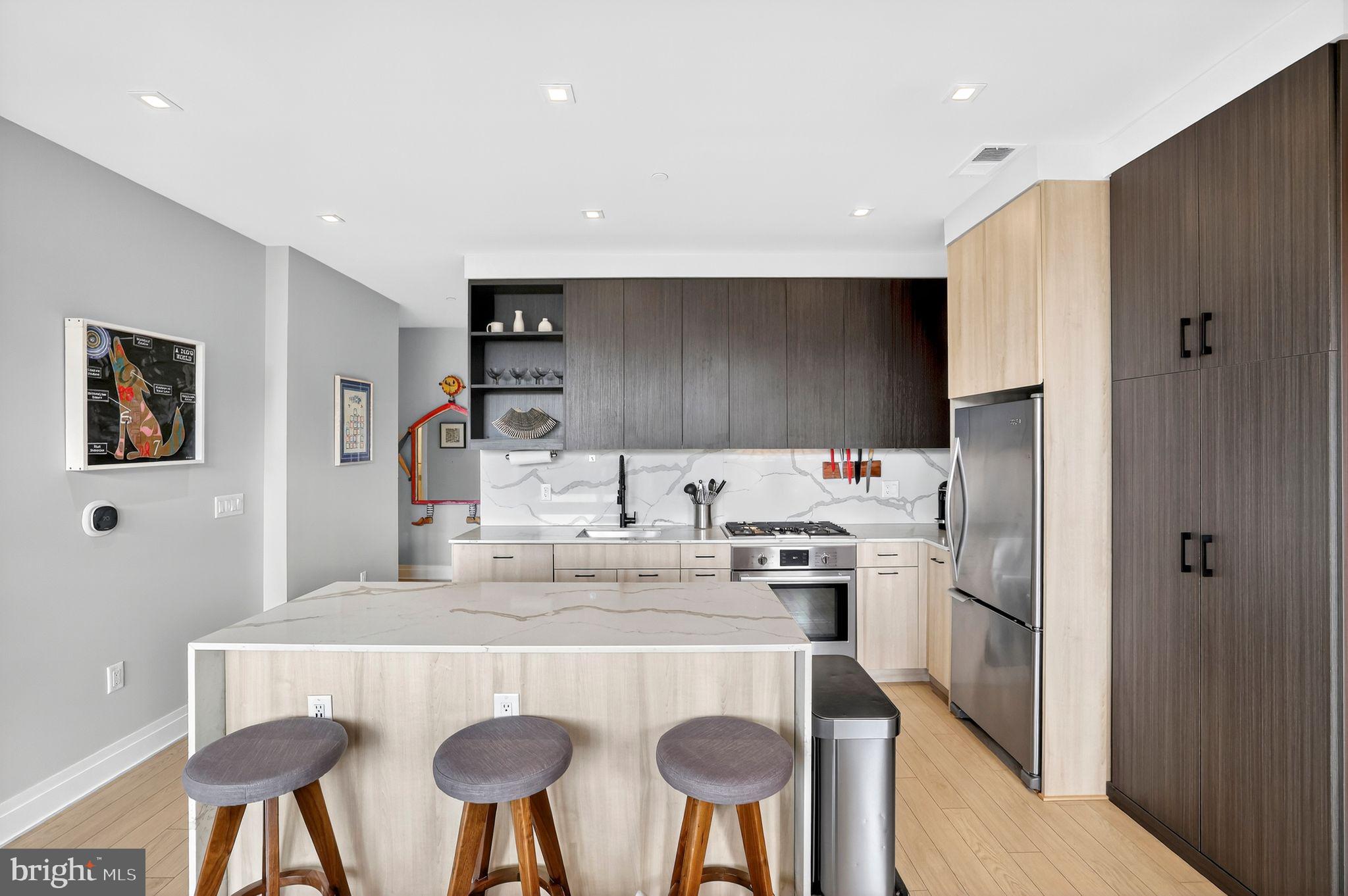 900 11th Street Southeast, Unit 308 Washington, DC 20003 - Photo 8 of 36 a kitchen with stainless steel appliances kitchen island granite countertop a refrigerator and a stove top oven