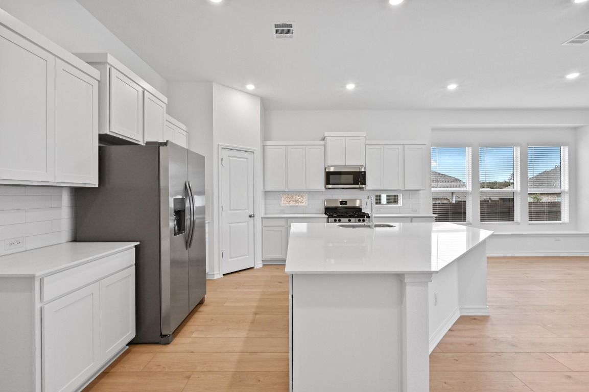 1617 Dove Rnch Road Georgetown, TX 78628 - Photo 6 of 25 a kitchen with stainless steel appliances a refrigerator stove microwave and cabinets