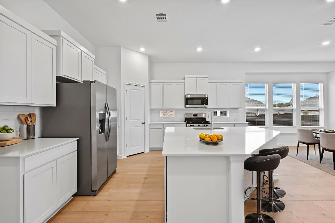 1617 Dove Rnch Road Georgetown, TX 78628 - Photo 7 of 25 a kitchen with stainless steel appliances a refrigerator sink and cabinets