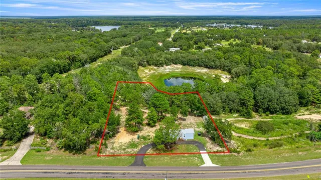 a view of a green field with lots of bushes