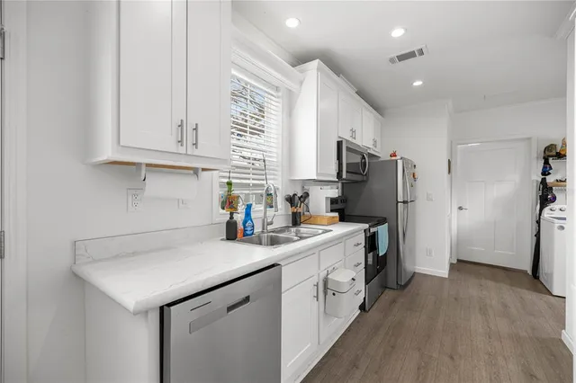 a kitchen with stainless steel appliances white cabinets and a refrigerator
