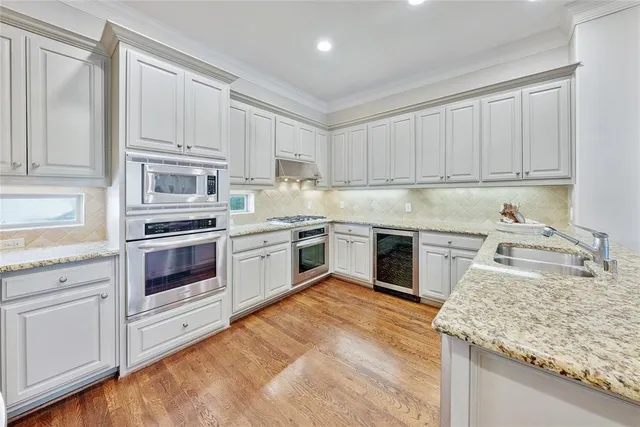 a kitchen with granite countertop white cabinets and white stainless steel appliances