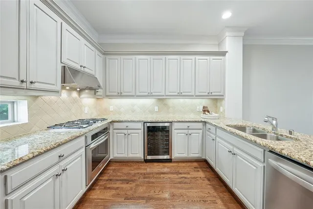 a kitchen with stainless steel appliances granite countertop a stove sink and cabinets