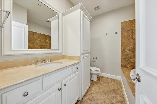 a bathroom with a granite countertop sink toilet and shower