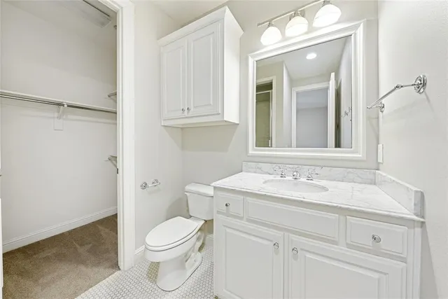 a bathroom with a sink vanity mirror and toilet