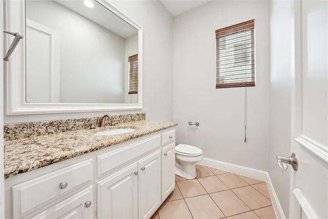 a bathroom with a granite countertop sink and a toilet