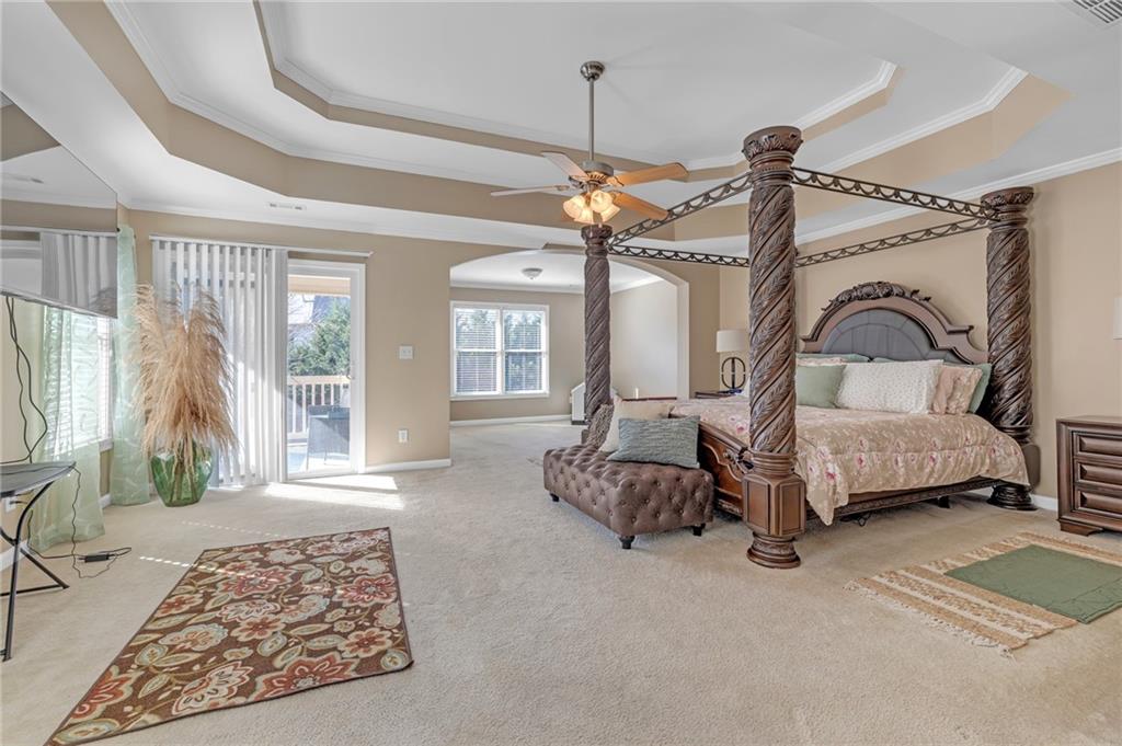 604 Arbor Ridge Loganville, GA 30052 - Photo 19 of 39 a bedroom with a bed a mirror and furniture