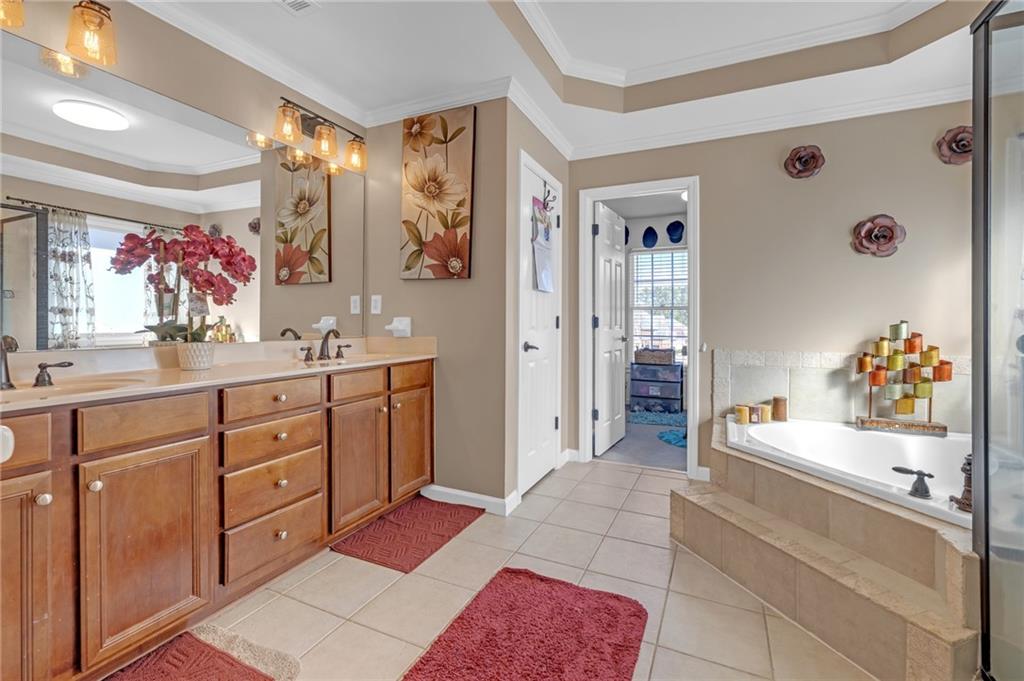 604 Arbor Ridge Loganville, GA 30052 - Photo 23 of 39 a spacious bathroom with a double vanity sink mirror and bathtub