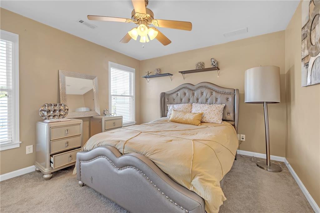 604 Arbor Ridge Loganville, GA 30052 - Photo 31 of 39 a bedroom with a bed and a chandelier