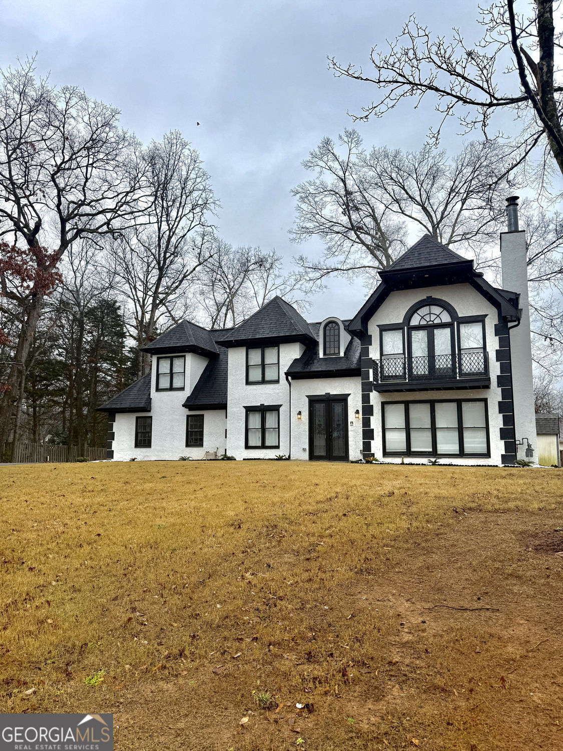a front view of a house with a garden and trees