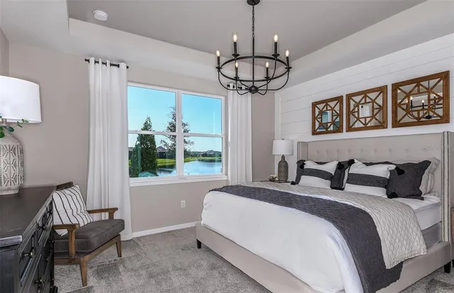 a bedroom with a bed and a chandelier