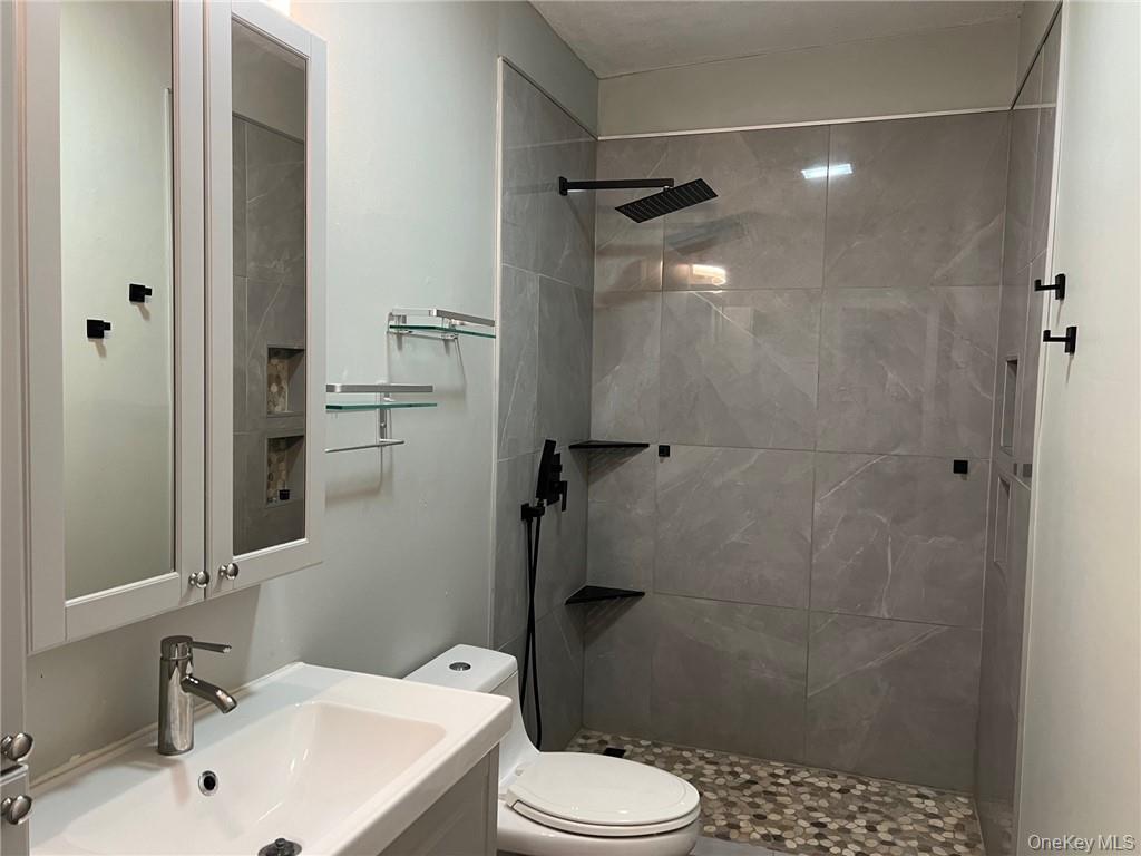 708 Silver Lake-Scotchtown Road Middletown, NY 10941 - Photo 16 of 25 Bathroom with a tile shower, vanity, and toilet