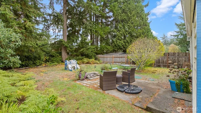 front view of a house with a yard and large trees