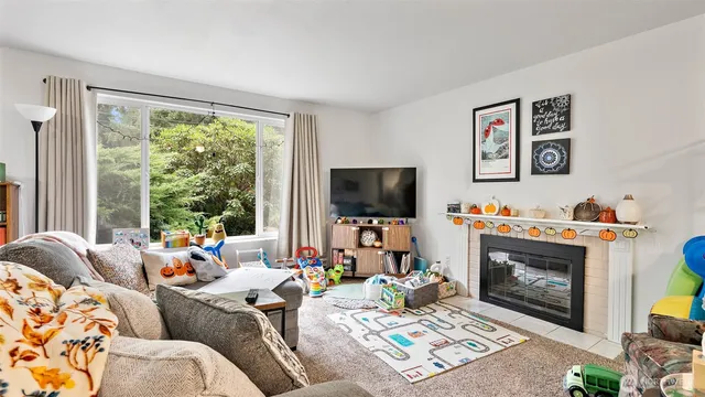 a living room with furniture a flat screen tv and a fireplace