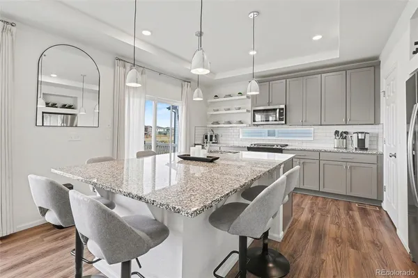 a kitchen with kitchen island a stove a chandelier and a refrigerator