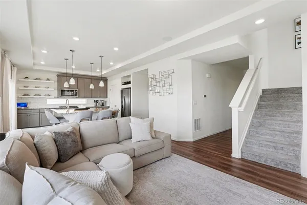 a living room with furniture and a view of kitchen