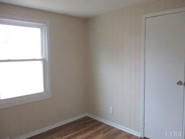 a view of a small space with wooden floor and a window