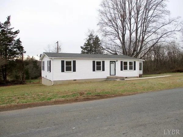 a view of a house with backyard and trees