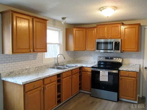 a kitchen with stainless steel appliances granite countertop a stove microwave and sink