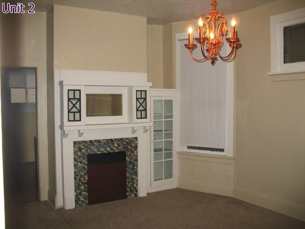 484 Teece Avenue Pittsburgh, PA 15202 - Photo 22 of 25 a view of a livingroom with a fireplace a chandelier and windows