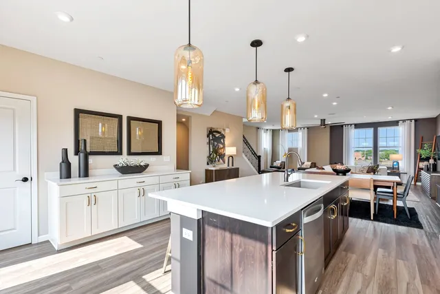 a kitchen with white cabinets appliances and wooden floor