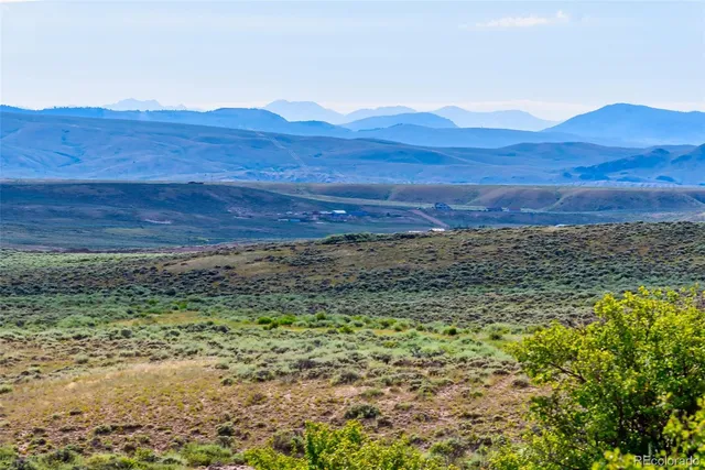 a view of a large mountain with sunset in background