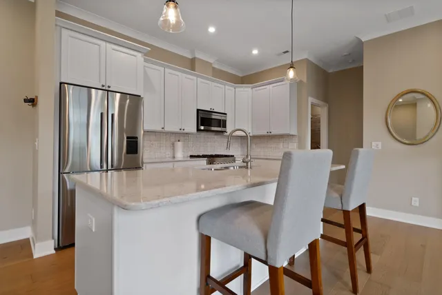 a kitchen with kitchen island a appliances dining table and chairs